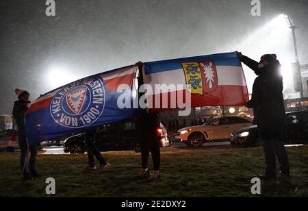 13. Januar 2021, Schleswig-Holstein, Kiel: Fußball: DFB-Pokal, Holstein Kiel - Bayern München, 2. Runde im Holstein-Stadion. Kieler Fans halten Fahnen und feiern mit einer Autokolonne. Der FC Bayern München ist sensationell aus dem DFB-Pokal ausgeschieden. Die Dreifachsieger verloren am Mittwochabend bei einem Elfmeterschießen gegen die Zweitligist Holstein Kiel. WICHTIGER HINWEIS: Gemäß den Bestimmungen der DFL Deutsche Fußball Liga und des DFB Deutscher Fußball-Bund ist es untersagt, im Stadion und/oder vom Spiel aufgenommene Fotos in Form von Sequenzbildern a zu verwenden oder zu verwenden Stockfoto