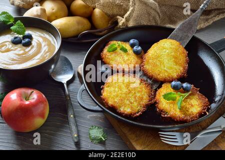 Knusprig gebratene Kartoffelpfannkuchen mit süßem Apfelmus und etwas Beeren Stockfoto