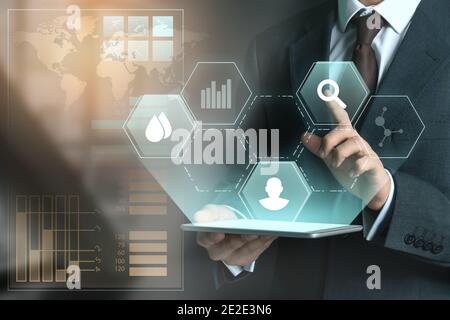 Geschäftsmann mit Tablet Computer mit virtuellen Bildschirm auf dunklem Hintergrund Stockfoto