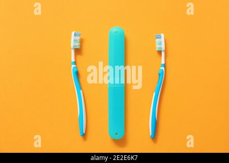 Zahnbürsten und Gehäuse auf farbigem Hintergrund Stockfoto