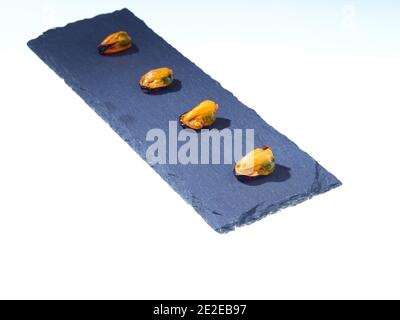 High-Angle-Schuss von verzinnten Muscheln mit einem braunen öligen Sauce auf einer Steinoberfläche Stockfoto