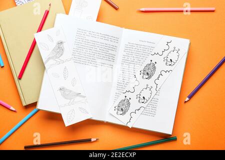 Niedliche Lesezeichen mit Büchern und Bleistiften auf farbigem Hintergrund Stockfoto