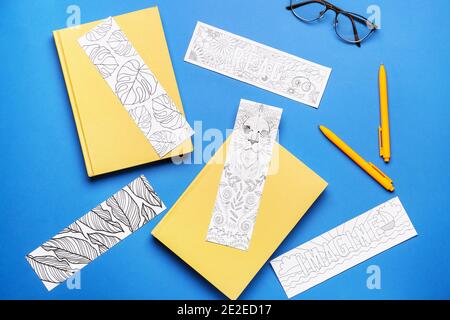 Niedliche Lesezeichen mit Büchern auf farbigem Hintergrund Stockfoto