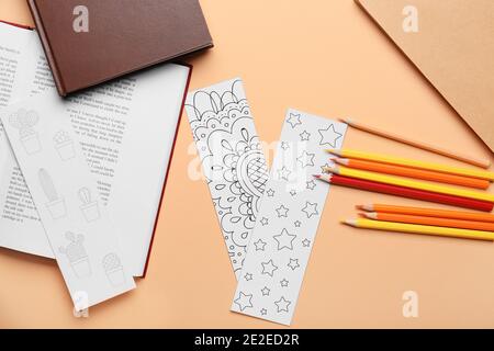 Niedliche Lesezeichen mit Büchern und Bleistiften auf farbigem Hintergrund Stockfoto