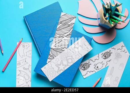 Niedliche Lesezeichen mit Büchern auf farbigem Hintergrund Stockfoto