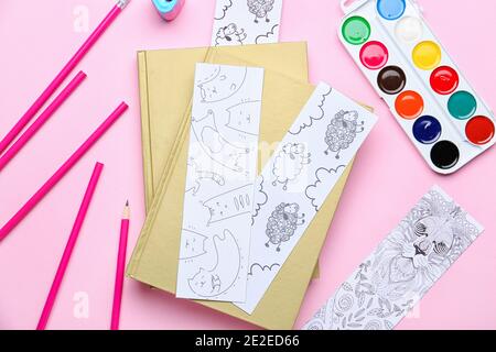 Niedliche Lesezeichen mit Büchern, Bleistiften und Farben auf farbigem Hintergrund Stockfoto