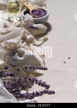 Handgemachte Lavendelsäckchen in Stofftaschen und Baumwollherzen auf Baumwoll-Tischdecke. Natürlicher Lebensstil mit geringer Auswirkung. Lavendelblüten in Pauspapier trocknen Stockfoto