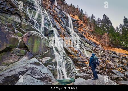 Junger Mann bewundert die Wasserfälle von Nardis im Val di Genova, Naturpark Adamello-Brenta in Norditalien Stockfoto