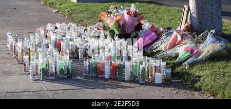 FRESNO, USA - 30. Dez 2020: Foto von Glaskerzen und Blumen auf dem Bürgersteig für die Opfer eines tödlichen Autounfalls an einem sonnigen Tag Stockfoto