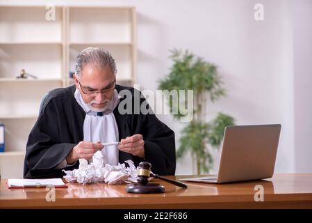 Alter männlicher Richter, der im Gerichtsgebäude arbeitet Stockfoto