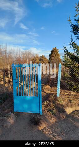 Vertikale Aufnahme eines blauen verschweißten Tores in einer Farm Stockfoto