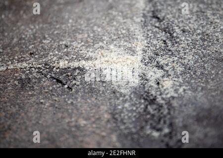 Der Bürgersteig ist mit rutschfestem Material besprüht. Wetter, Frost und rutschig. Stockfoto