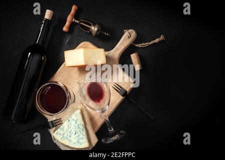 Wein- und Käseverkostung, Overhead-Aufnahme auf schwarzem Hintergrund, mit einem Vintage-Korkenzieher und einer Flasche, mit einem Ort für Text Stockfoto