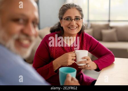 EINE ÄLTERE ERWACHSENE FRAU UND EIN EHEMANN SCHAUTEN GLÜCKLICH IN DIE KAMERA Stockfoto