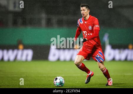 13. Januar 2021, Schleswig-Holstein, Kiel: Fußball: DFB-Pokal, Holstein Kiel - Bayern München, 2. Runde, im Holstein-Stadion. Der Münchner Robert Lewandowski spielt den Ball.(wichtiger Hinweis: Der DFB verbietet die Verwendung von Sequenzbildern im Internet und in Online-Medien während des Spiels (einschließlich Halbzeit). Sperrfrist! Das DFB erlaubt die Veröffentlichung und Weiterverwendung der Bilder auf mobilen Geräten (insbesondere MMS) und über DVB-H und DMB erst nach Ende des Spiels). Foto: Christian Charisius/dpa - WICHTIGER HINWEIS: Gemäß den Vorschriften der DFL Deutsche Fußball Liga und Stockfoto