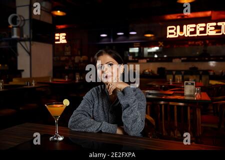 Porträt einer Frau mit einem Glas Saft in einem Restaurant. Stockfoto