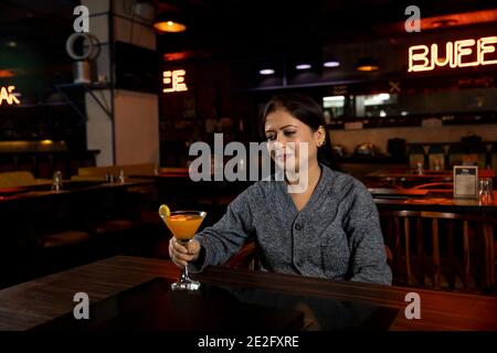 Porträt einer Frau mit einem Glas Saft in einem Restaurant. Stockfoto