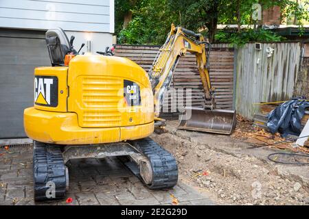 Mini Bagger graben einen Graben mechanisch zu reparieren eine gebrochene Drainageschlauch, Sydney, Australien Stockfoto