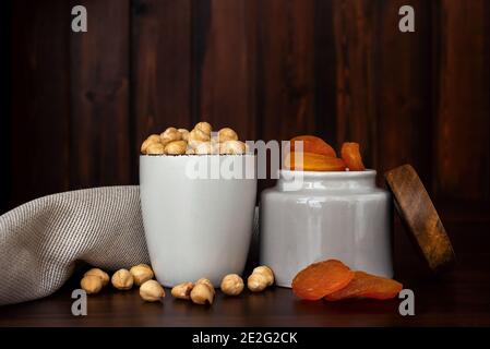 Schüsseln mit brasilianischen Nüssen und getrockneten Aprikosen auf Holztisch. Trockenfrüchte und Nüsse Konzept Stockfoto