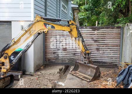 Mini Bagger graben einen Graben mechanisch zu reparieren eine gebrochene Drainageschlauch, Sydney, Australien Stockfoto