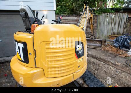 Mini Bagger graben einen Graben mechanisch zu reparieren eine gebrochene Drainageschlauch, Sydney, Australien Stockfoto