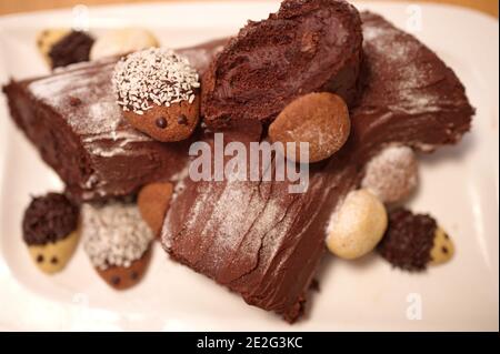 Geschmückter Weihnachts-Schokoladenkuchen mit Plätzchen auf weißem Teller Stockfoto