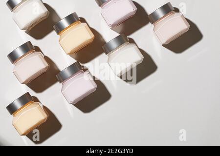 Kosmetische Creme in Gläsern auf pastellgrauem Hintergrund. Schönheit und Hautpflege. Draufsicht: Platz für die Kopie des flachen Laymusters. Stockfoto