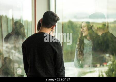 Selektive Fokusaufnahme eines netten glücklichen Paares, das in steht Vorderseite eines Fensters Stockfoto