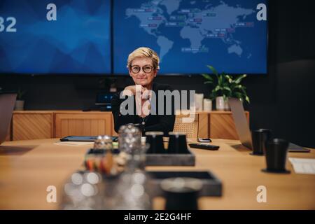 Porträt einer reifen Geschäftsfrau, die im Besprechungsraum sitzt. Weibliche professionelle Unternehmen Blick auf Kamera. Stockfoto
