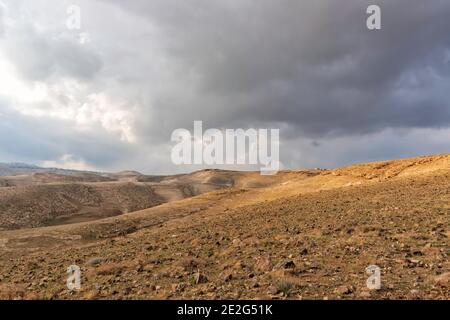 Blick auf die felsigen Hügel der Judäischen Wüste unter stürmischem Himmel. Querformat Stockfoto