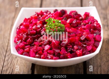 Schüssel mit traditionellen russischen Rüben Salat Vinaigrette auf Holztisch Stockfoto