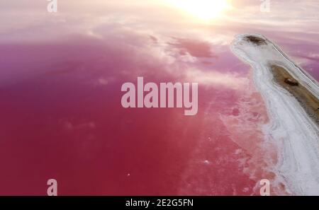 Schönes rosa Wasser im See und ein dramatischer Himmel und die aufgehende Sonne. Stockfoto