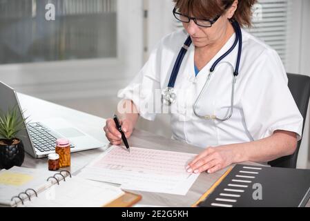 Kardiologin, die in der medizinischen Praxis ein EKG-Diagramm untersucht Stockfoto