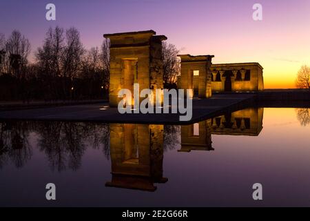 Ägyptischer Tempel von Debod beleuchtet bei Sonnenuntergang und reflektiert im Wasser des Teiches. Madrid, Spanien. Leerzeichen für Text. Stockfoto