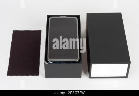 Auspacken von Touchscreen-Smartphone, Papierkarton und sauberen Tuch. Studio-Aufnahmen auf weißem Hintergrund. Stockfoto