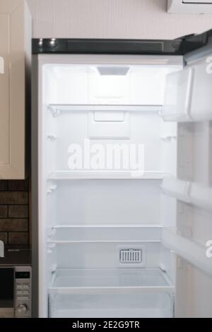 Leerer offener weißer Kühlschrank in der Küche. Hochwertige Fotos Stockfoto
