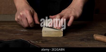 Messer schärfen mit Schleifstein/Block Stockfoto