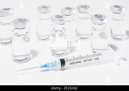 COVID-19 Impfstofffläschchen und Spritze auf weißem Hintergrund Stockfoto
