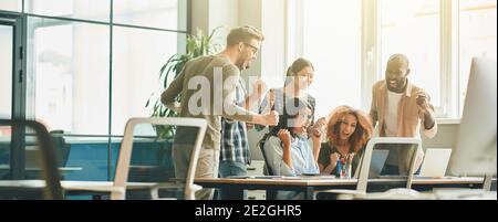 Tatkräftige junge Menschen feiern den Erfolg ihres Projekts bei der Arbeit Stockfoto