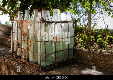 Metallkiste von alten staubigen Glasflaschen in einem alten Keller in einem Dorfhaus gefunden, Bulgarien Stockfoto
