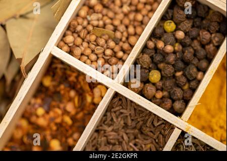 Ein Set verschiedener Gewürze in einer Holzkiste. Nahaufnahme, selektiver Fokus Stockfoto