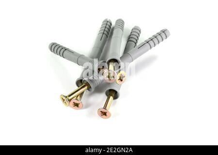 Wandstecker - auch als Schraubenanker oder Dübel bekannt, in verschiedenen Farben und Größen auf einem Stapel, isoliert auf weiß, Kunststoff-Werkzeug Stockfoto