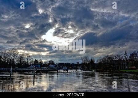 Dunkle Sturmwolken über der Themse bei Shepperton Wehr an einem Wintertag, Surrey England UK Stockfoto