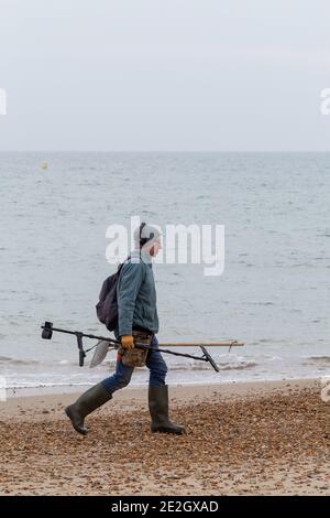 Mann mit Metalldetektor geht entlang Bournemouth Strand in der Winter 30 November 2020 Neil Turner Stockfoto