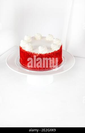 Roter Samtkuchen auf Weiß mit Schlagsahne in Scheiben isoliert Bereit zum Servieren Stockfoto