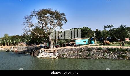 Kalna, Westbengalen, Indien. Blick über den Fluss Hooghly, Teil des Ganges. Die Landschaft und das Dorf entlang des Flusses Hooghly auf dem kultivierten Stockfoto