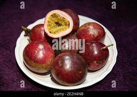 Maracuya oder Passionsfrucht in weißem Teller, Nahaufnahme. Frische exotische Früchte. Stockfoto