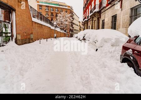 Mehrere Autos von Schnee bedeckt von der Passage des Sturms Filomena in der Innenstadt von Madrid; Spanien. Stockfoto