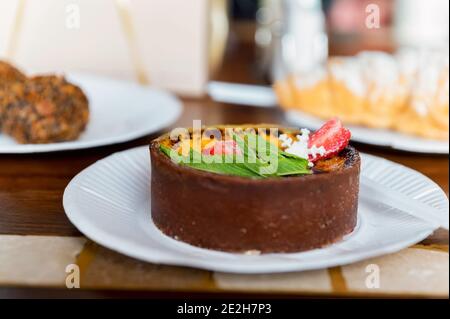 Creme Brulee Kuchen mit Weihnachtsschmuck mit Erdbeeren und Minze auf einem Teller. Romantisches Frühstückskonzept. Selektiver Fokus Stockfoto