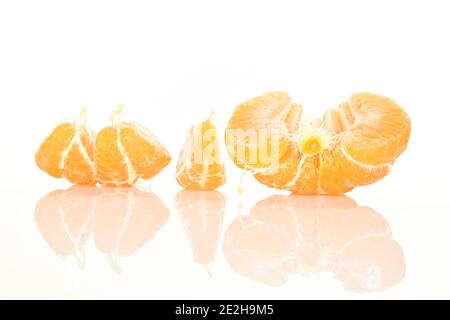 Mehrere geschälte, gelb reife süße Mandarinenscheiben auf weißem Grund. Stockfoto